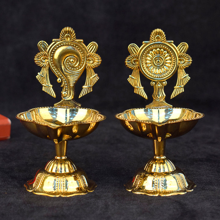 Elegant pair of designer Shankh and Chakra brass diyas, beautifully handcrafted for spiritual rituals, pooja ceremonies, and festive decoration. India’s Largest Pooja Accessories Brand – www.satvikworld.com