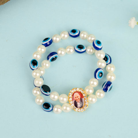 White Pearl with Evil Eye Double Layer Guruji Swaroop Bracelet featuring luminous pearls and a protective blue evil eye bead with Jai Guruji Swaroop – perfect for spiritual wear, protection, and gifting. India’s Largest Pooja Accessories Brand – www.satvikworld.com