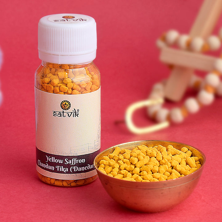 Danedar Yellow Chandan Tika (Saffron Chandan Tilak) in a round container, used for applying auspicious tilak during Hindu rituals and religious ceremonies. India’s Largest Pooja Accessories Brand – www.satvikworld.com