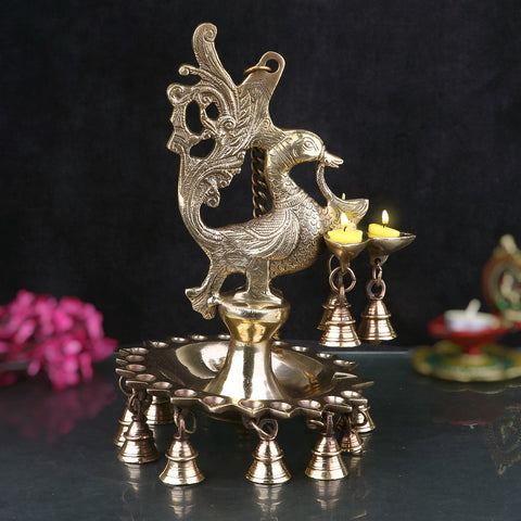 Brass Peacock Diya with intricate design and hanging bells, adding an elegant touch to spiritual ceremonies and home decor. India’s Largest Pooja Accessories Brand – www.satvikworld.com